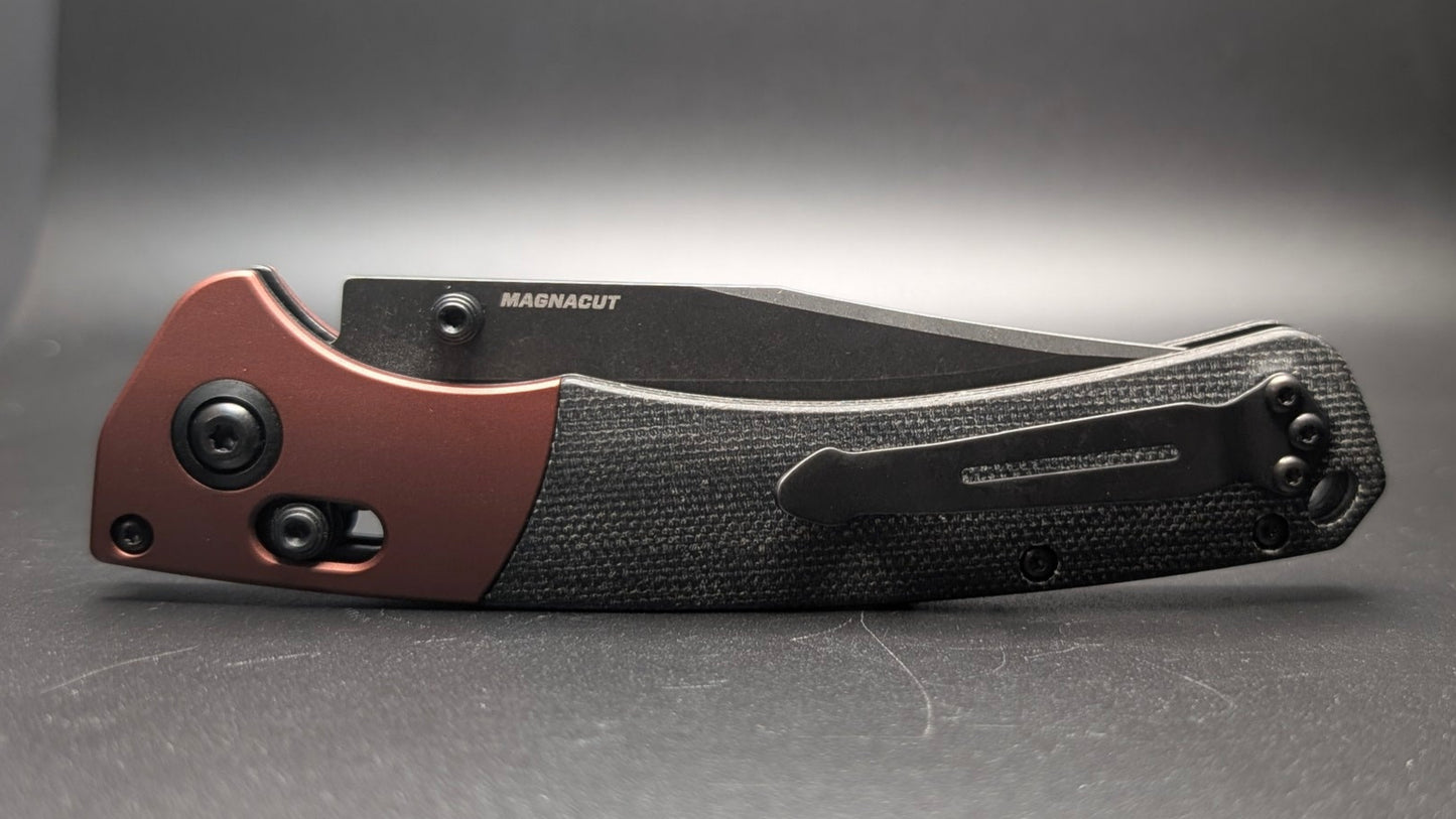 Folding knife with a brown and black handle on a gray background