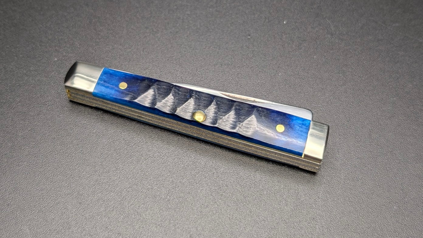 Small rectangular object with blue and silver design on a dark surface