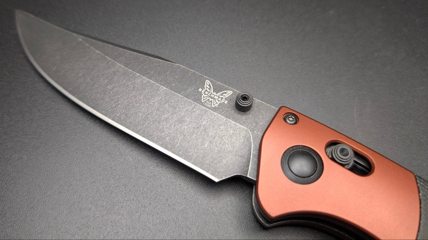Folding knife with a copper handle on a dark gray background