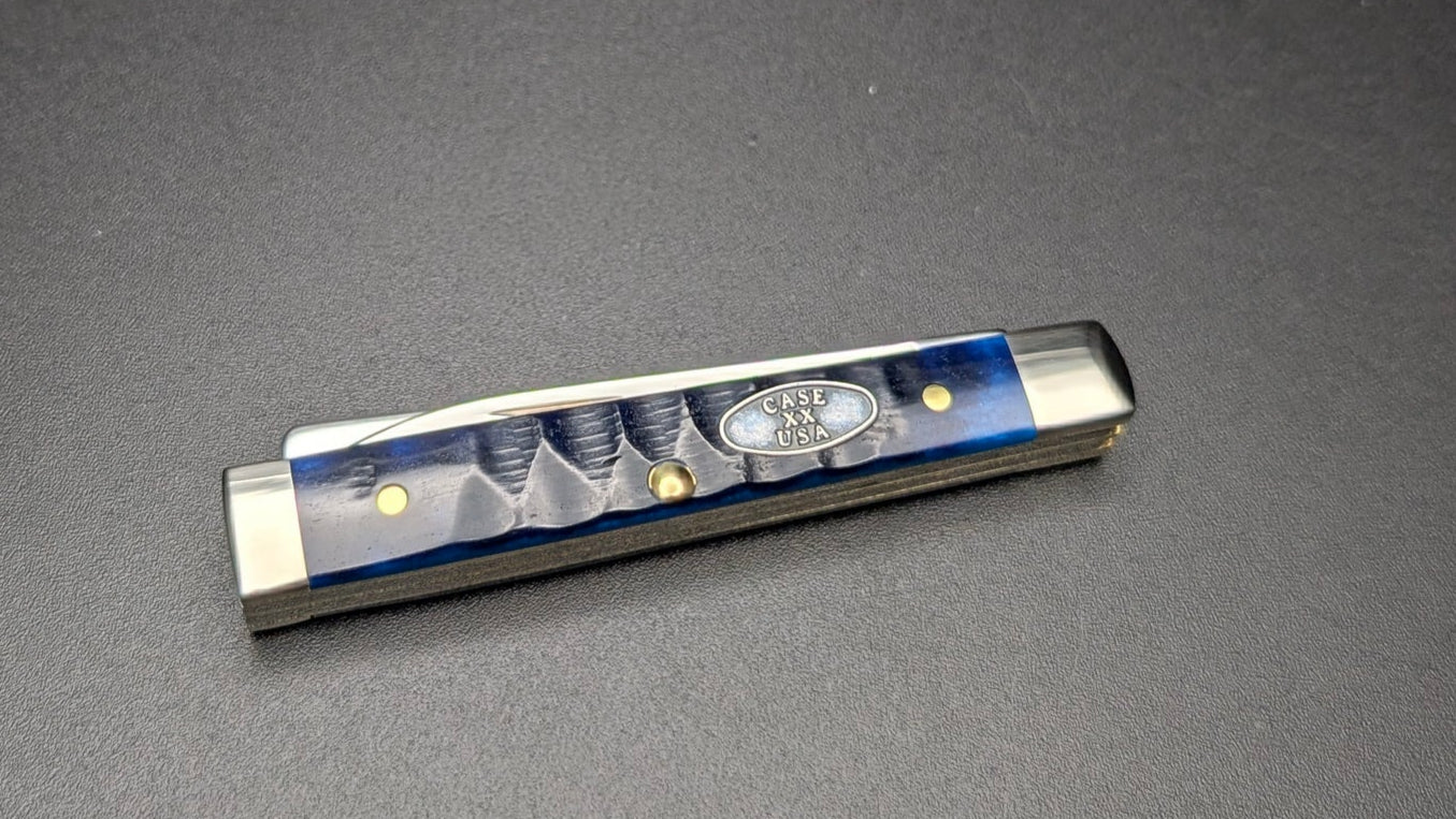 Small rectangular object with blue and silver design on a dark gray background