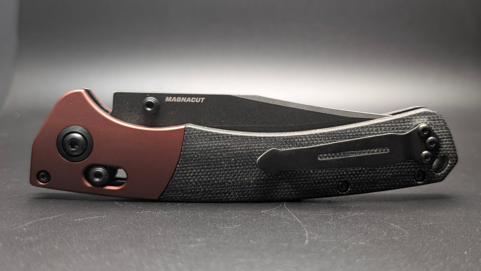 Folding knife with a brown and black handle on a gray background
