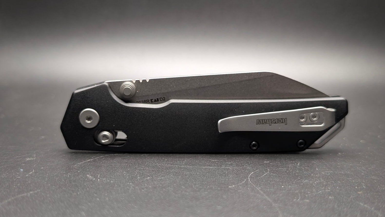 Black folding knife on a gray background