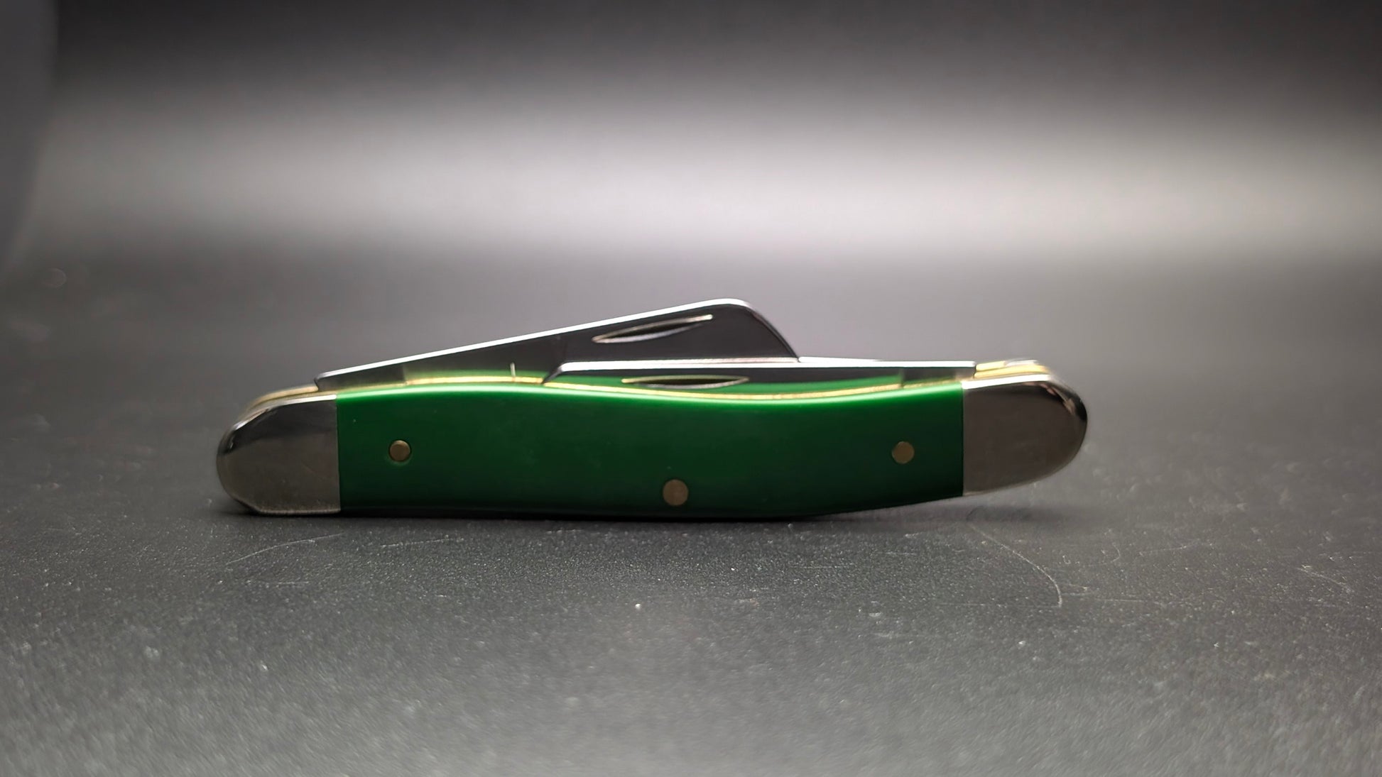 Case Green Synthetic Smooth Medium Stockman Model #53392 Pattern (4318 SS) Closed Back on a Gray surface
