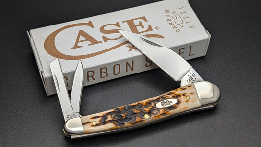 Case knife with Amber Bone handle on a dark surface with Case brand box in the background.