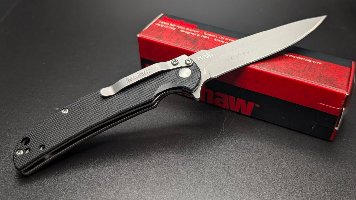 Folding knife with a red box on a dark surface