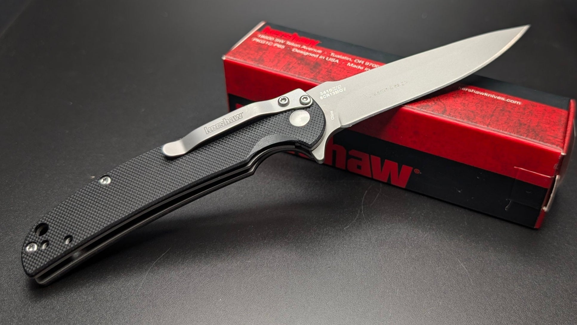 Folding knife with a red box on a dark surface