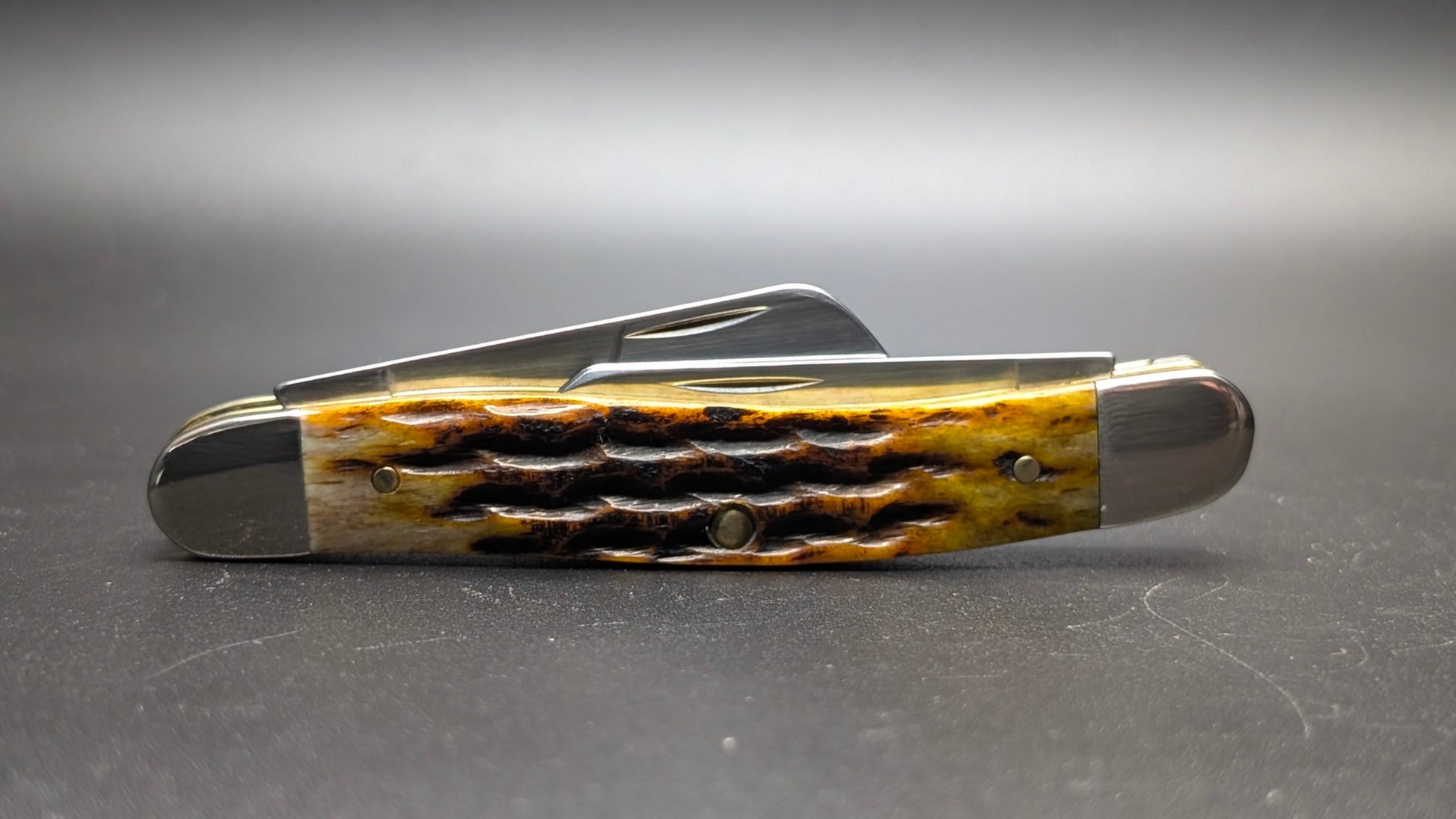 Case Honeycomb Bone Heritage Jig Medium Stockman Model #32272 Pattern (6318 SS) Closed Back on a Gray Surface