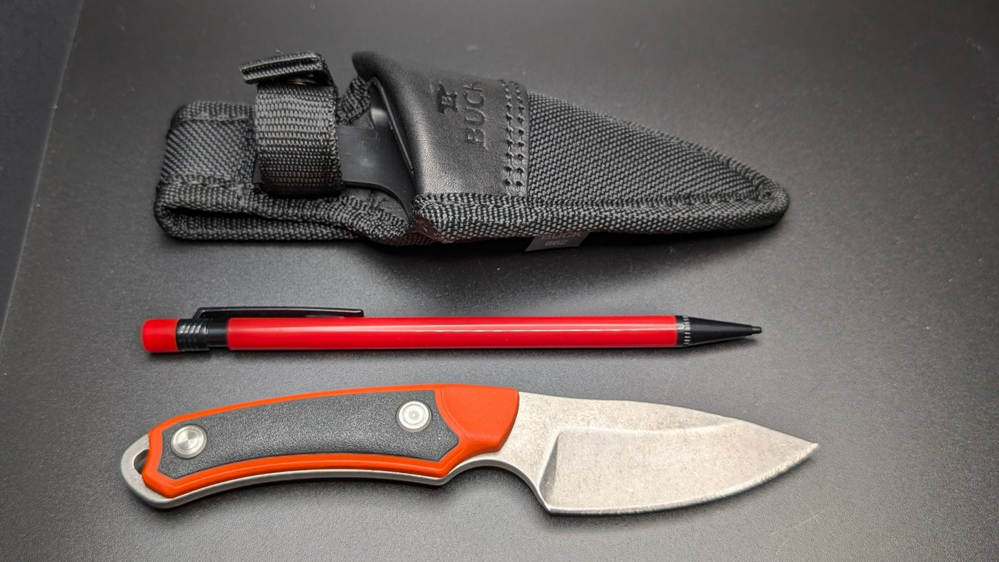 Fixed blade and black Sheath, pen, and sheath on a gray surface